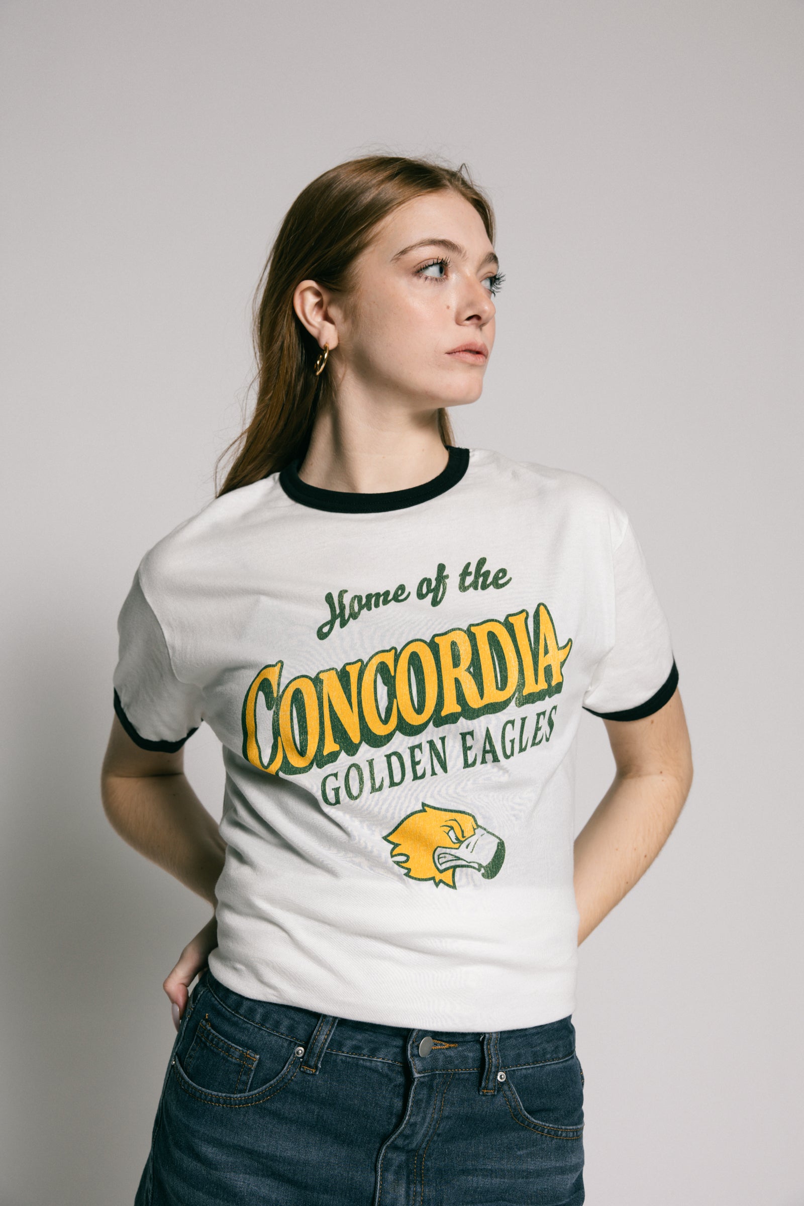 Person wearing a white t-shirt with 'Home of the Concordia Golden Eagles' text and logo.
